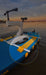 Blue and yellow water scooter on a body of water with a sunset sky.