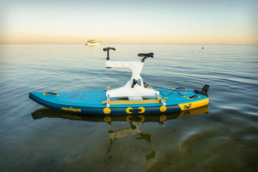 Blue and black stand-up paddleboard with a white motor on calm water at sunset.