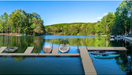 Lake with dock and boats surrounded by trees on a clear day