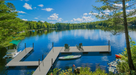 Dock with boats on a calm lake surrounded by trees