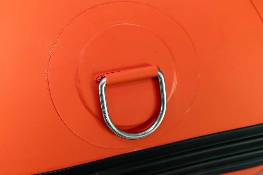 Close-up of an orange suitcase handle with a metal ring