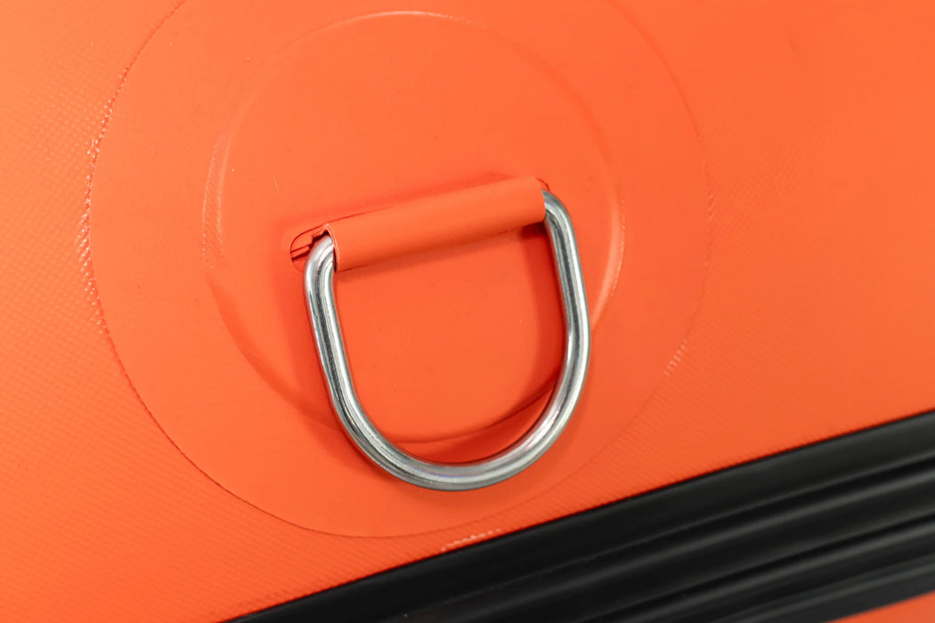 Close-up of an orange luggage handle with a metal ring
