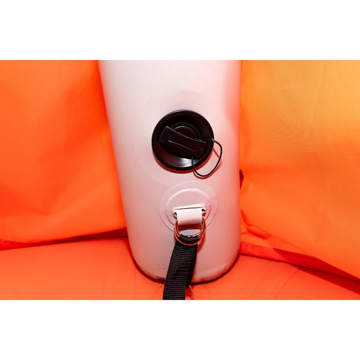 Close-up of a pink inflatable seat with a black strap and valve on an orange background