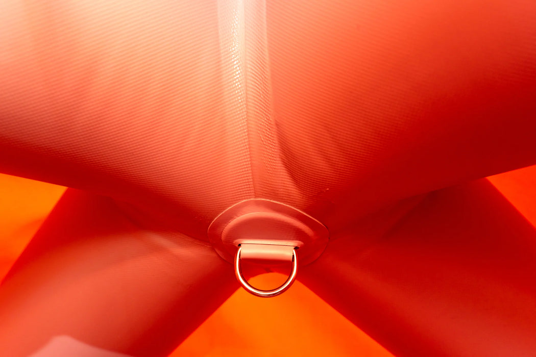 Close-up of a red fabric bow with a metal ring in the center.