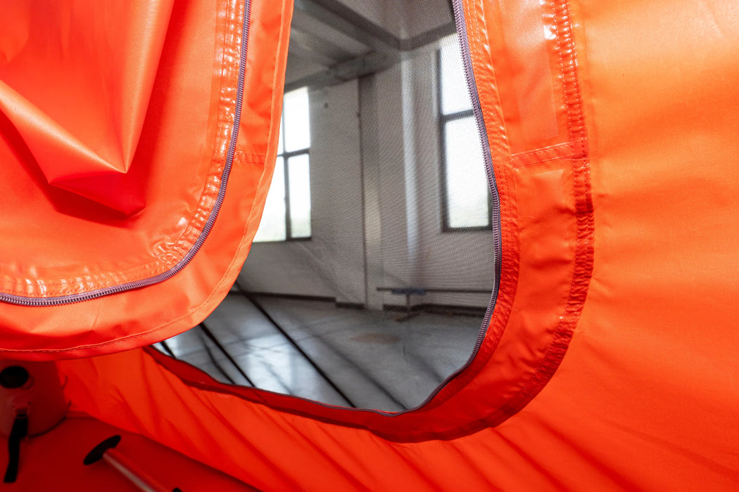 Close-up of an orange inflatable boat with a white interior, showing the floor and side walls.