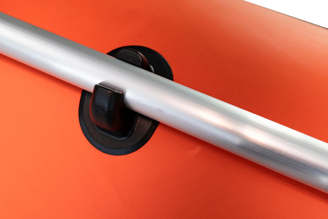 Close-up of a metal bar with a black clip on an orange background