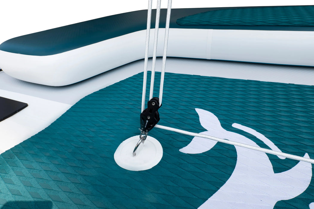 Close-up of a white anchor on a teal and white inflatable boat with a dolphin design.