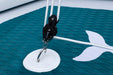 Close-up of a sailboat's rigging with a white hook on a teal sail.