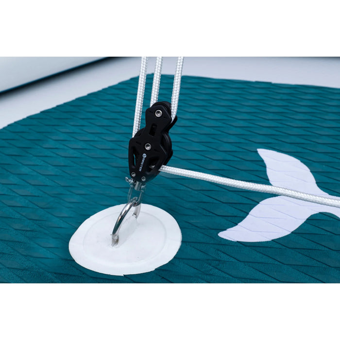 Close-up of a sailboat's rigging with a white hook on a teal sail.