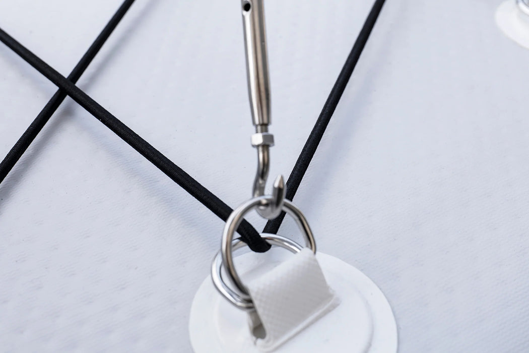 Close-up of a white electronic device with a black cable on a light gray background