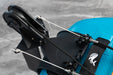 Close-up of a blue helmet with a black chin strap and helmet mount on a gray background
