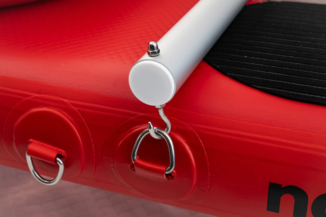 Close-up of a red inflatable boat with a white handle and metal ring.