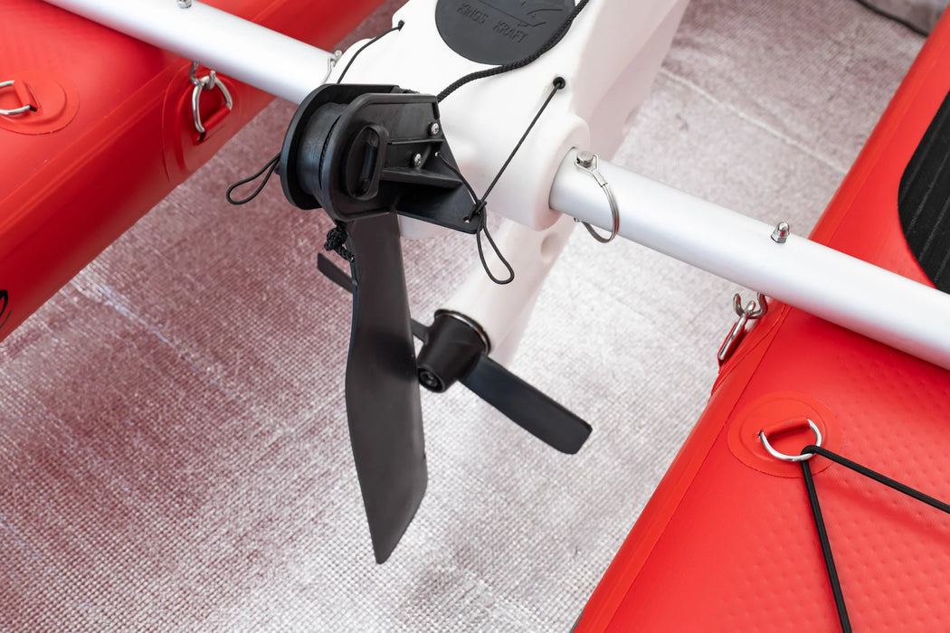 Close-up of a red and white electric scooter with a black propeller on a textured surface.