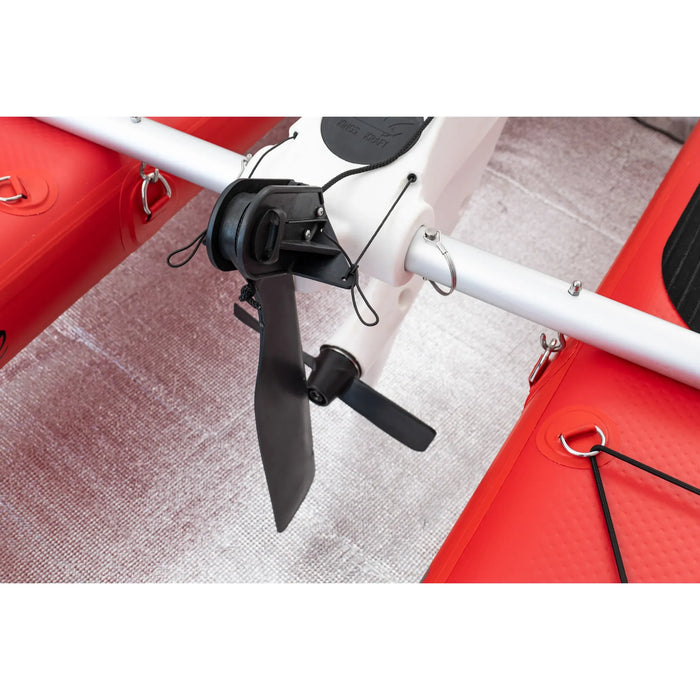 Close-up of a red and white electric scooter with a black propeller on a textured surface.