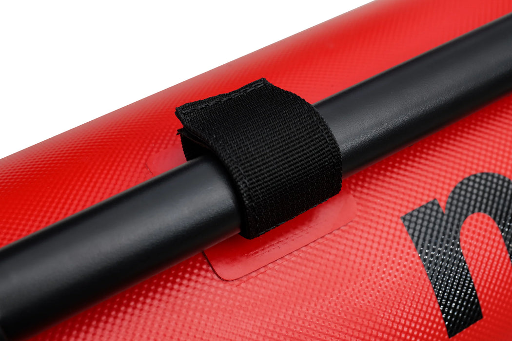 Black strap securing a black pole to a red surface with a visible brand logo.