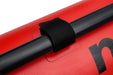 Black strap securing a black pole to a red surface with a visible brand logo.