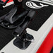 Close-up of a black motorcycle foot peg on a red and white motorcycle.