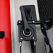 Close-up of a black mechanical component on a vehicle door with red and gray background